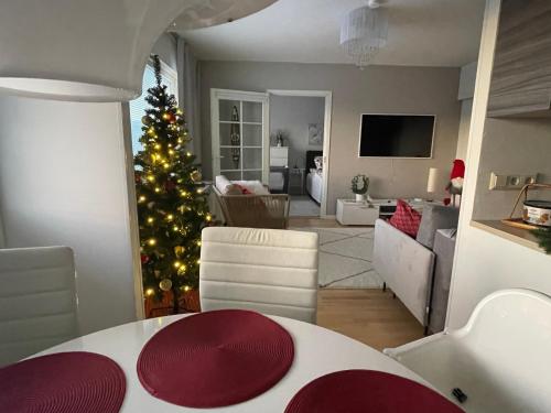 ein Wohnzimmer mit einem Weihnachtsbaum und einem Wohnzimmer in der Unterkunft Peaceful City Centre Apartment (2 Bdr) in Rovaniemi
