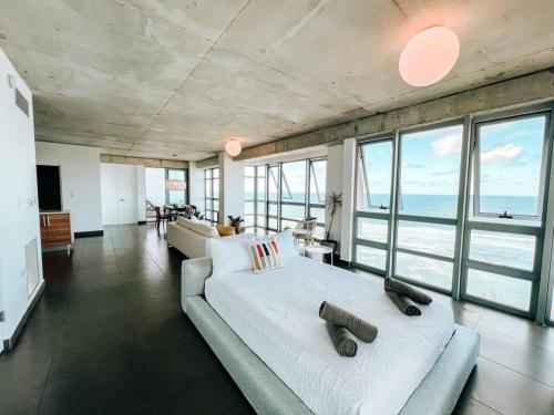 Luxurious SubPh Apt Atlantis W/ Ocean View & PRK في سان خوان: غرفة معيشة كبيرة مع سرير كبير وأريكة