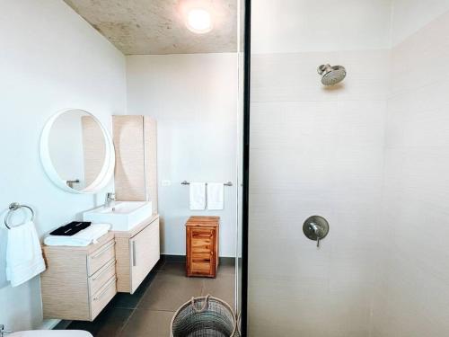 a white bathroom with a sink and a shower at Luxurious SubPh Apt Atlantis W/ Ocean View & PRK in San Juan