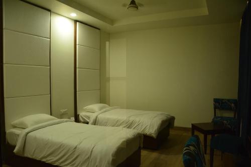 a room with two beds and a mirror at Green Hotel & Restaurant in Pathānkot