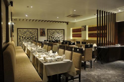 uma sala de jantar com mesas, cadeiras e mesa em Green Hotel & Restaurant em Pathānkot
