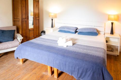a bedroom with a large bed with blue sheets and blue pillows at De Rusty Farm in De Rust