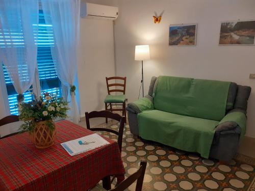 a living room with a green couch and a table at Calypso in Cefalù
