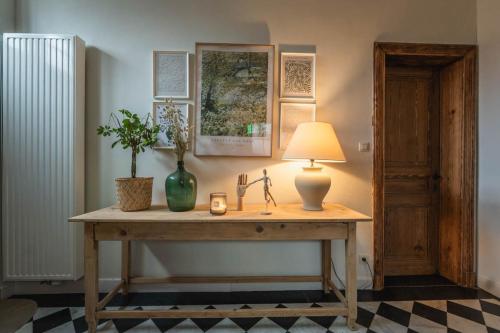 een tafel met een lamp en een plant erop bij Maison Comtale in Rochefort