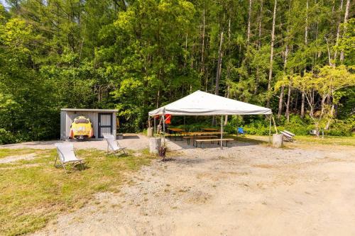 a tent and a table and chairs in a field at Tinyhouses - Domain "La vallée des Prés" in Bande