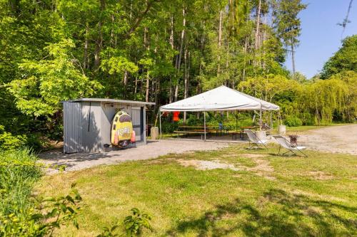 a tent and a table and chairs in a yard at Tinyhouses - Domain "La vallée des Prés" in Bande