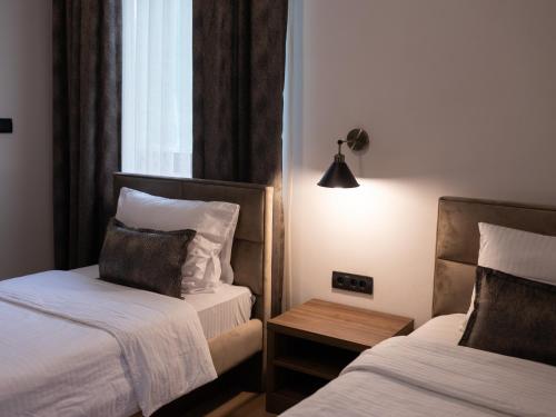 ein Hotelzimmer mit 2 Betten und einem Tisch in der Unterkunft Hotel RAS Pazarište in Novi Pazar