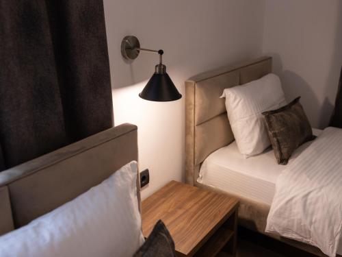 a bedroom with a bed and a table and a lamp at Hotel RAS Pazarište in Novi Pazar