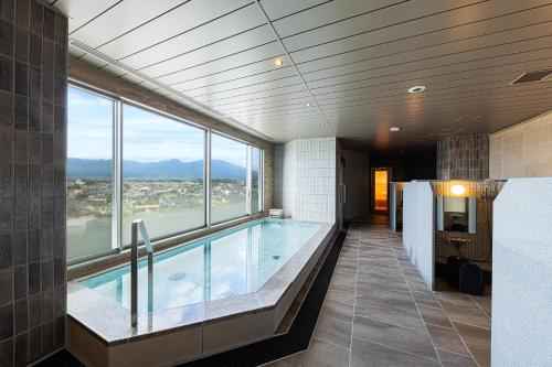 a swimming pool in a building with a large window at AQA Hotel Premium in Saku