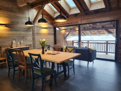une salle à manger avec une table et des chaises en bois dans l'établissement The Loft - unique apartment, NR MORZINE, à La Côte dʼArbroz