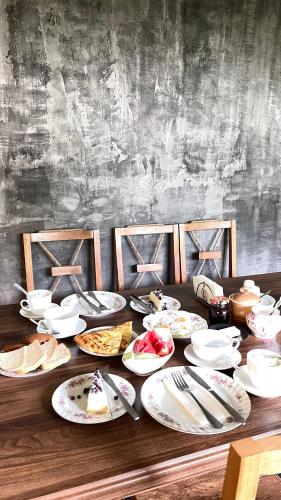 a wooden table with plates of food on it at Guesthouse Chela in Mestia