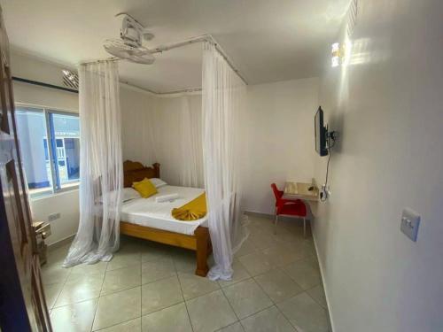 - une chambre avec un lit et une moustiquaire dans l'établissement Mtwapa Texas Villa Guest House, à Mtwapa