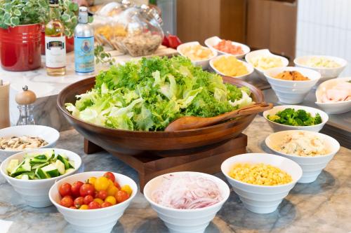 a table topped with bowls of vegetables and other foods at AQA Hotel Premium in Saku