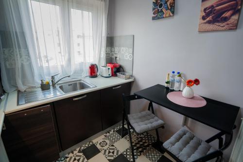 a small kitchen with a sink and a table at Chic Studio Old City Center - IVO19 in Bucharest