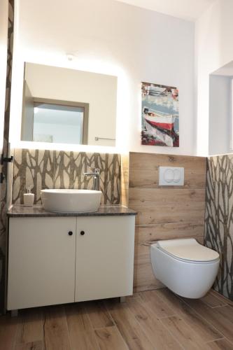 La salle de bains est pourvue d'un lavabo, de toilettes et d'un miroir. dans l'établissement Swiss Apartmani, à Banja Luka