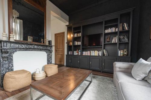 sala de estar con chimenea y sofá en Maison Comtale, en Rochefort