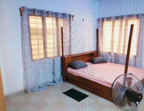 - une chambre avec un lit, un ventilateur et une fenêtre dans l'établissement Guest house In benin, à Abomey-Calavi