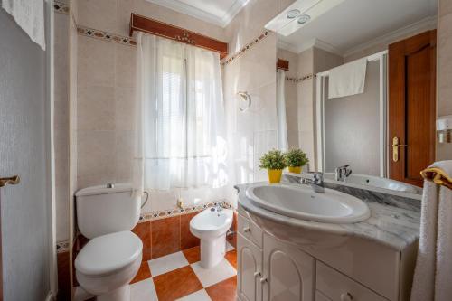 a bathroom with a toilet and a sink and a tub at Sevilla Sol in Seville