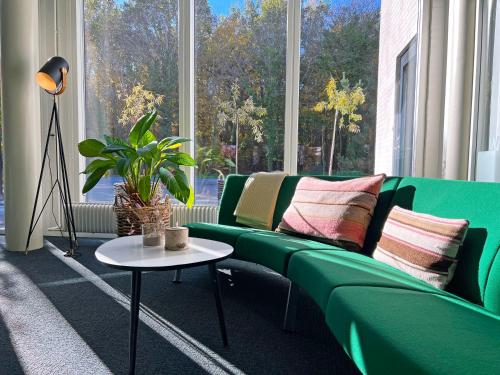 a living room with a green couch and a table at Hotel GSH in Rønne