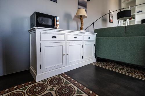 a white cabinet with a tv on it next to a couch at Plaza Apartment in Bitonto