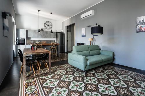 a living room with a green chair and a table at Plaza Apartment in Bitonto