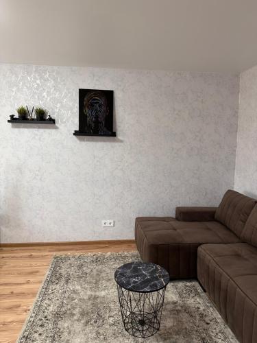 sala de estar con sofá marrón y pared en Jaukus butukas en Kėdainiai