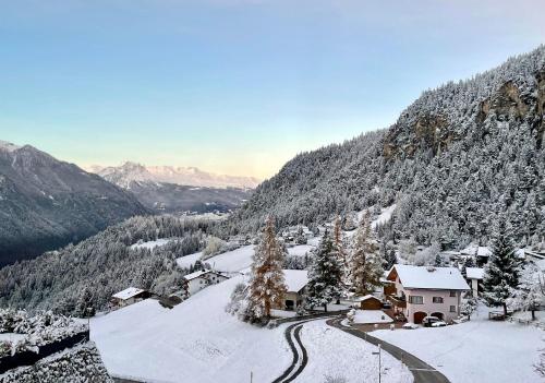 a snow covered mountain with a house and a road at Sonnige Panorama Aussicht bei Davos Lenzerheide in Schmitten