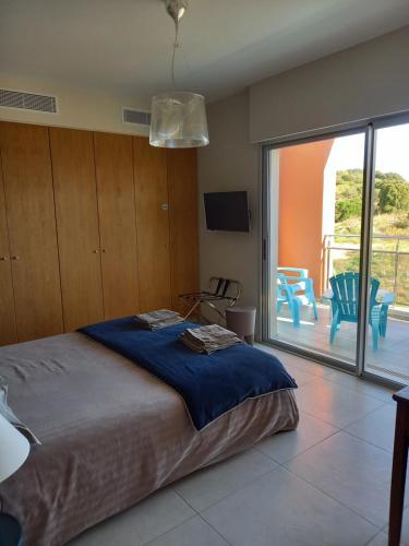 a bedroom with a bed and a sliding glass door at Suite avec 2 chambres d'hôtes pour 1 à 4 personnes avec terrasse, vue mer, parking privé, proche port et aéroport in Ajaccio