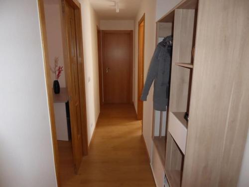 a hallway with a door and a coat hanging on a shelf at El Enebro in Lerma