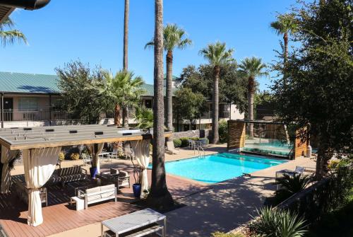 una piscina con terraza y un complejo en Ramada by Wyndham Del Rio, en Del Rio