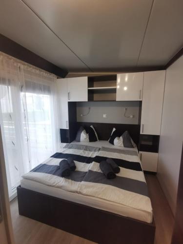 a large bedroom with a large bed with two pillows at Mobilehome Mali No 2 in Pakoštane