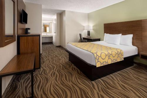 a hotel room with a bed and a desk at Baymont by Wyndham Griffin in Griffin