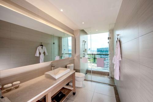 un bagno con lavandino, WC e specchio di Hyatt Place Sanya City Center a Sanya