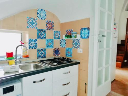 a kitchen with blue and white tiles on the wall at Studio in pieno centro in Capri
