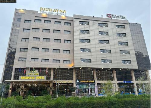 a tall building with a sign on top of it at Jouhayna Hotel&Suite in Erbil