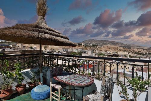 - un balcon avec une table et un parasol dans l'établissement Dar Borj, à Fès