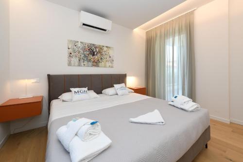 1 dormitorio con 1 cama grande y toallas. en MGH Luxury - Villa Celeste, en Desenzano del Garda