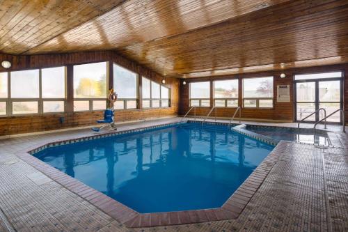 a large swimming pool in a building with windows at Travelodge by Wyndham Merrill in Merrill