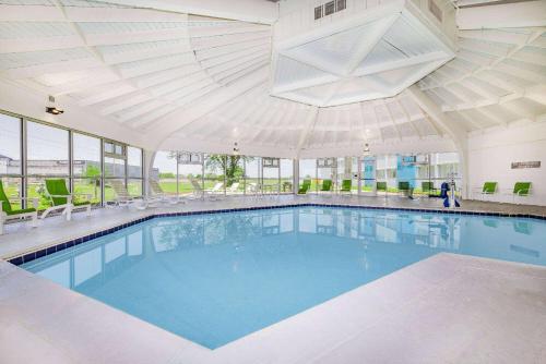 a large swimming pool in a building with a large ceiling at Hawthorn Extended Stay by Wyndham Wichita Airport in Wichita