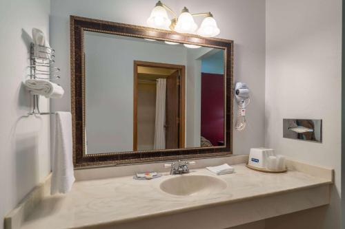 a bathroom with a sink and a mirror at Travelodge by Wyndham Merrill in Merrill