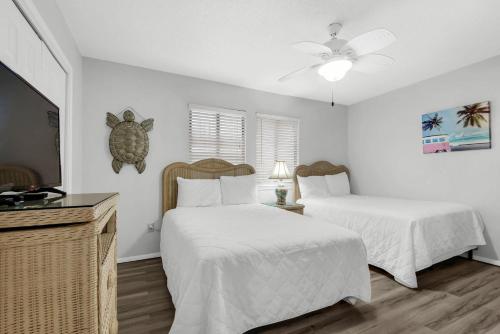 a bedroom with two beds and a ceiling fan at Sugar Beach F-26 in Navarre