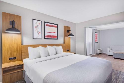 un grande letto bianco in una camera d'albergo di Hawthorn Extended Stay by Wyndham Wichita Airport a Wichita