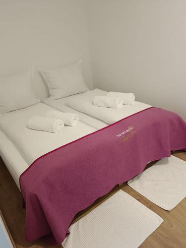 Una cama con una manta morada encima. en LiNZ CITY SUITE en Linz