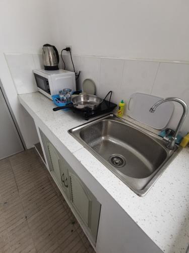 a kitchen counter with a sink and a microwave at AA Apartment in Koh Samui 