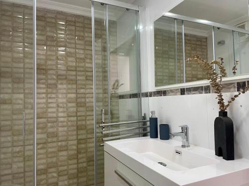 uma casa de banho com um lavatório e uma cabina de duche em vidro. em Casa Calma Los Tajillos - a 150 metros de la playa em Torremolinos