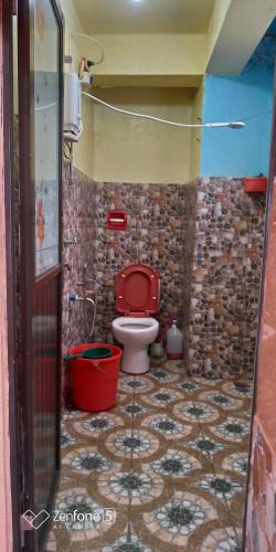 La salle de bains est pourvue de toilettes et d'un siège rouge. dans l'établissement Blue Haven Unit 1, à Baguio