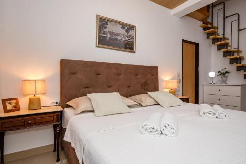 a bedroom with a large white bed with towels on it at Exquisite Villa with Heated Pool, Sauna, Breathtaking Landscape & Panoramic Views in Banjol in Rab
