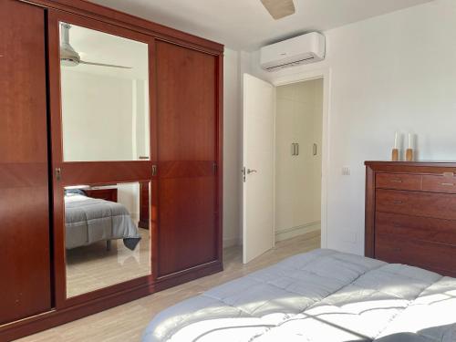 a bedroom with a bed and a dresser with a mirror at Casa Calma Los Tajillos - a 150 metros de la playa in Torremolinos