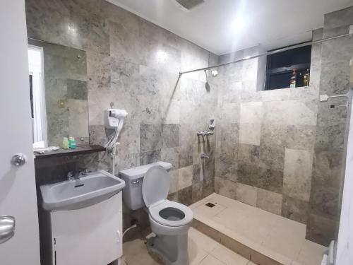 uma casa de banho com um WC, um lavatório e um chuveiro em Accommodation services-anne em Manila