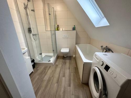a bathroom with a shower and a washing machine at B&B Immobilien GbR in Xanten